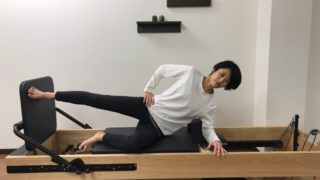 ピラティスリフォーマーでVMOアクティベーションをする女性