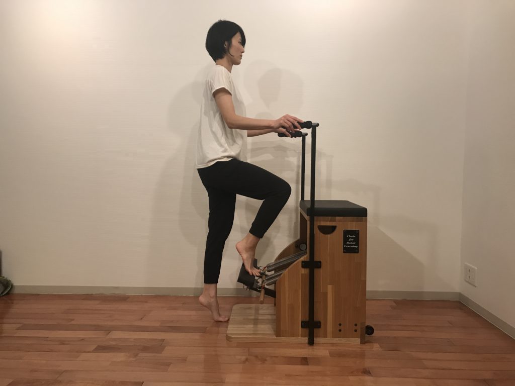 ピラティスチェアで足部のエクササイズをする女性の写真
