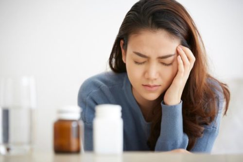 頭痛薬を飲む女性